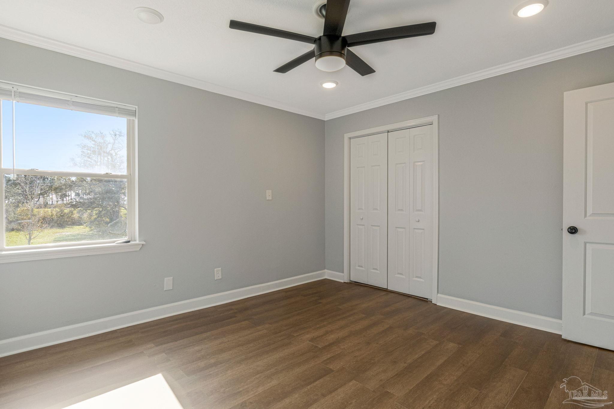 302 Garcon Point Road Milton, FL 32583 - Photo 25 of 51 a view of empty room with wooden floor and fan