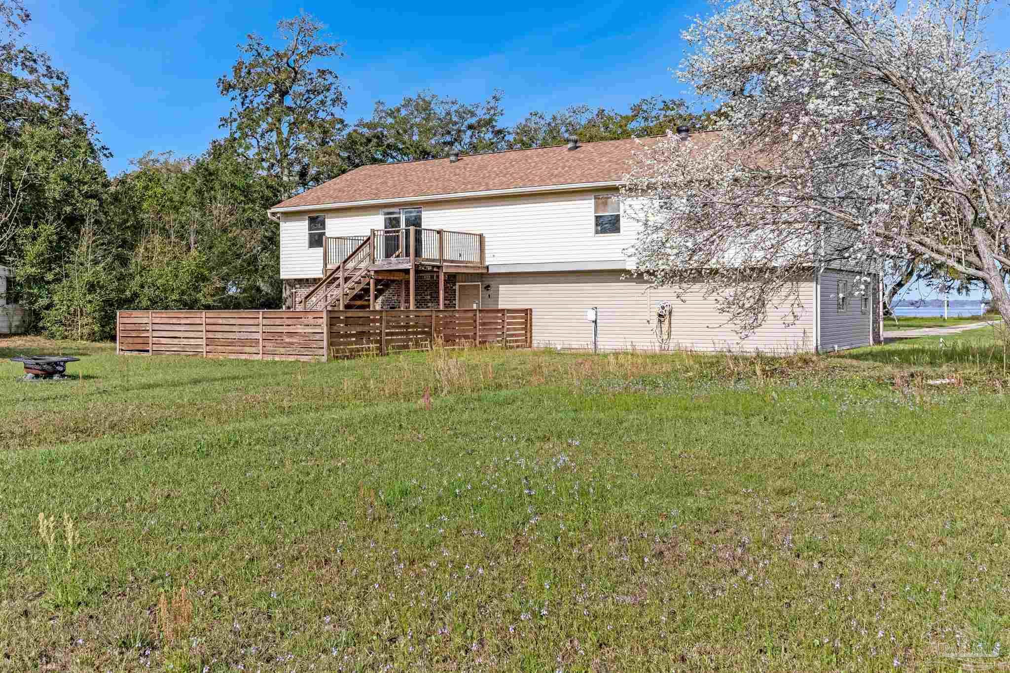 302 Garcon Point Road Milton, FL 32583 - Photo 40 of 51 a front view of house with yard and trees in the background