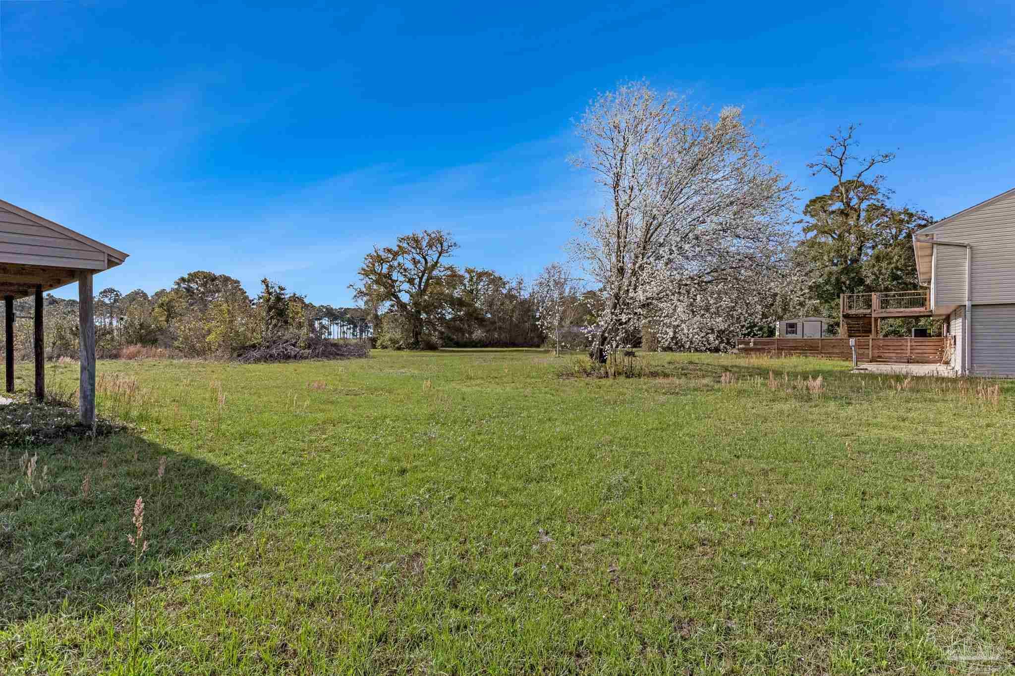 302 Garcon Point Road Milton, FL 32583 - Photo 42 of 51 a view of a garden with a building in the background