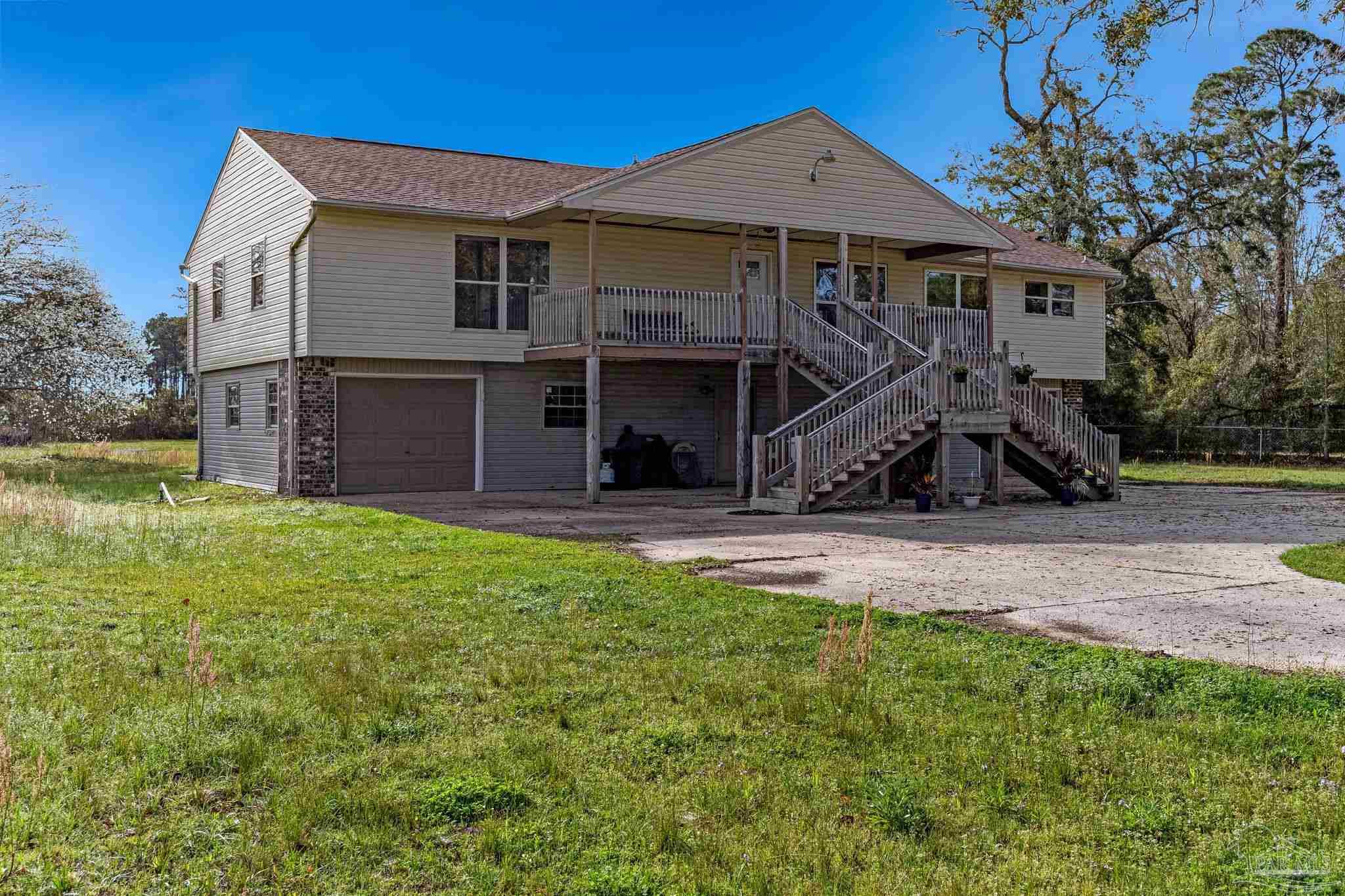 302 Garcon Point Road Milton, FL 32583 - Photo 5 of 51 a front view of a house with a yard