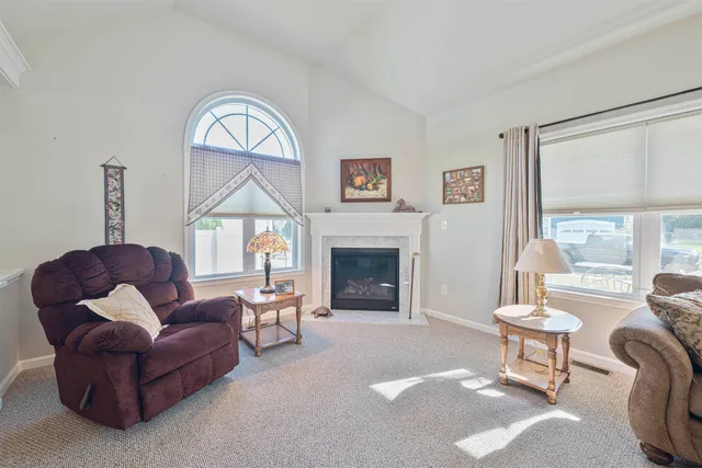 a living room with furniture a fireplace and a large window