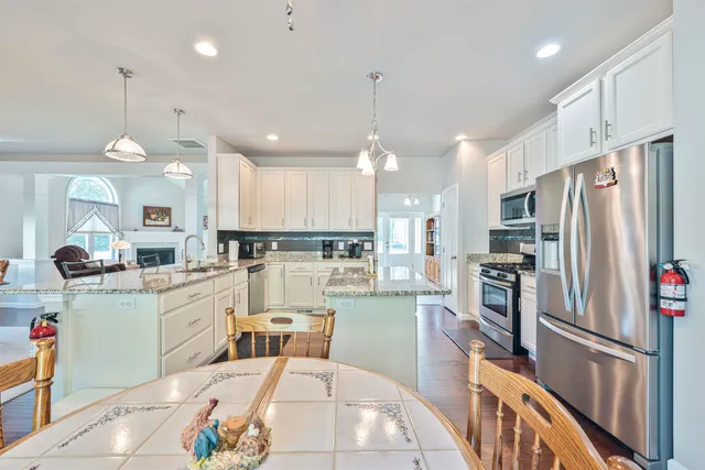 a large kitchen with kitchen island a large counter space stainless steel appliances and cabinets