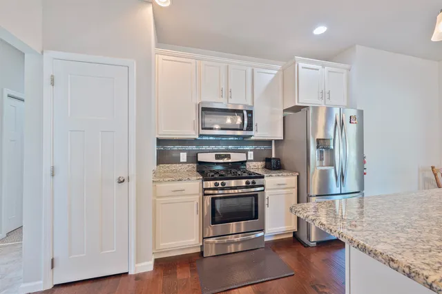 a kitchen with a refrigerator stove and wooden cabinets