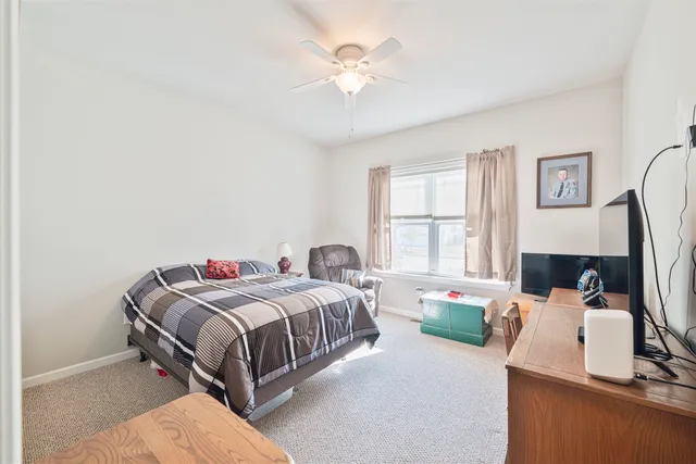 a bedroom with a bed a couch and a large window with the outer view