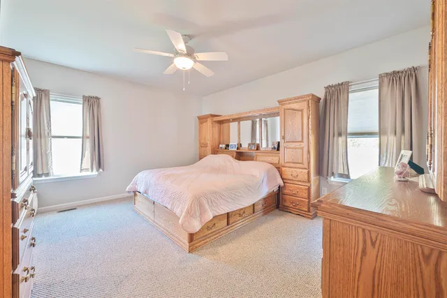 a spacious bedroom with a large bed and a chandelier