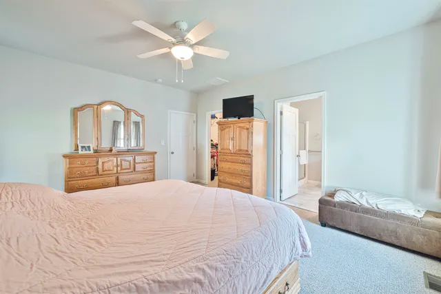 a bedroom with a large bed and a chandelier