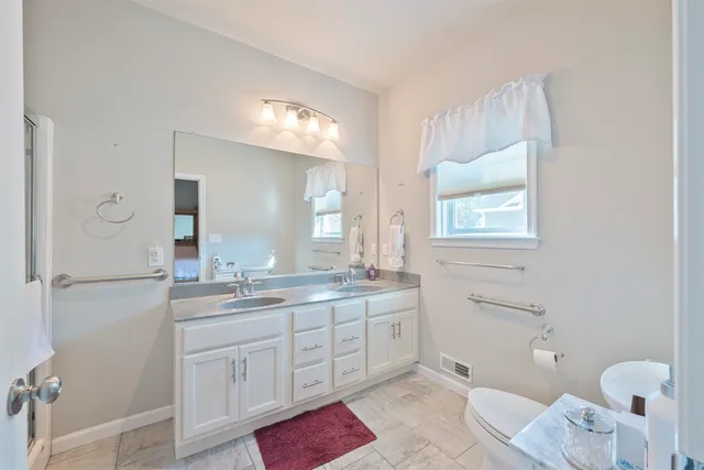 a spacious bathroom with a granite countertop sink mirror and a toilet