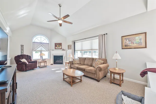 a living room with furniture a fireplace and a window