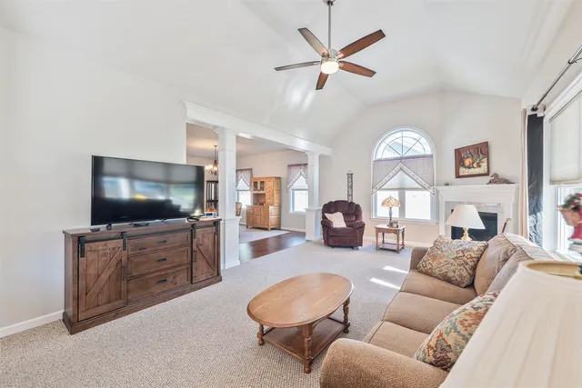 a living room with furniture a flat screen tv and kitchen view