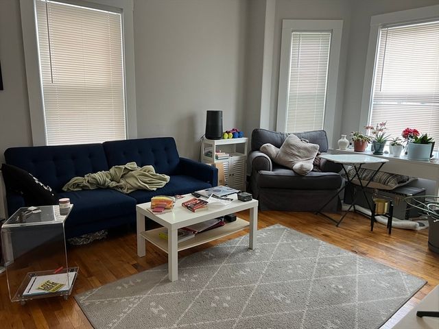 a living room with furniture a rug and a window