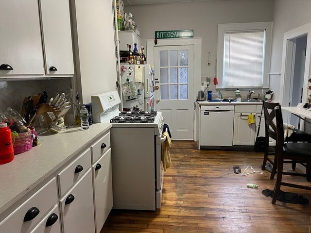 a kitchen with sink refrigerator and cabinets