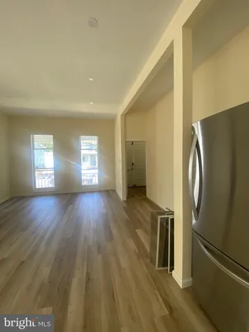 a view of a kitchen with wooden floor electronic appliances and windows