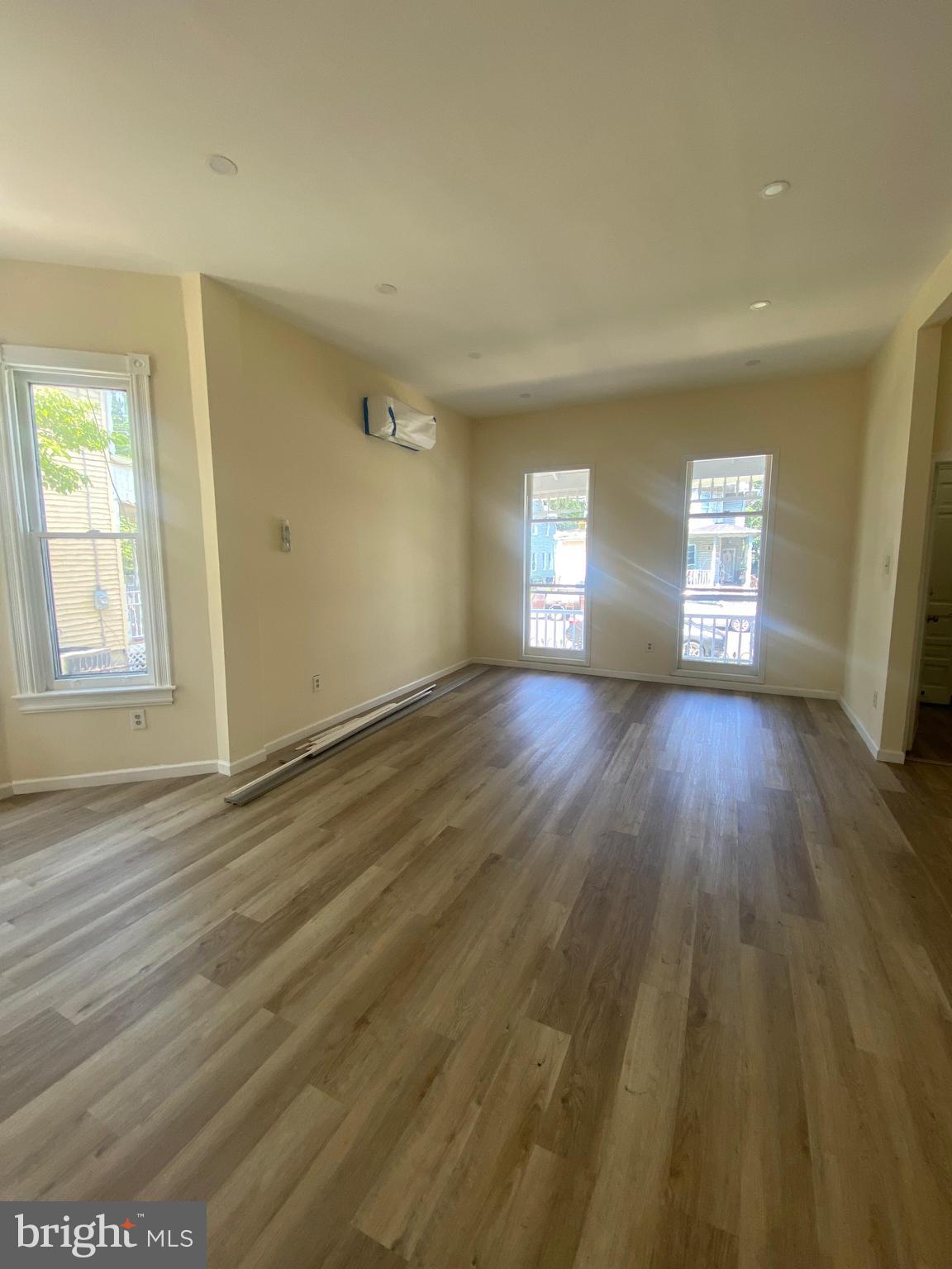 724 Hunter Street Gloucester City, NJ 08030 - Photo 5 of 47 an empty room with wooden floor and windows
