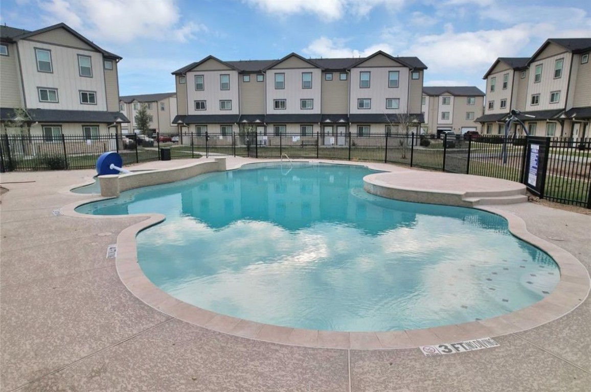 12603 Telge Road, Unit 28C Cypress, TX 77429 - Photo 23 of 25 a view of a swimming pool in front of a brick building