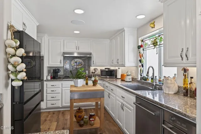 a kitchen with white cabinets and appliances