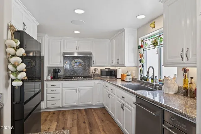 a kitchen with stainless steel appliances granite countertop a sink and cabinets