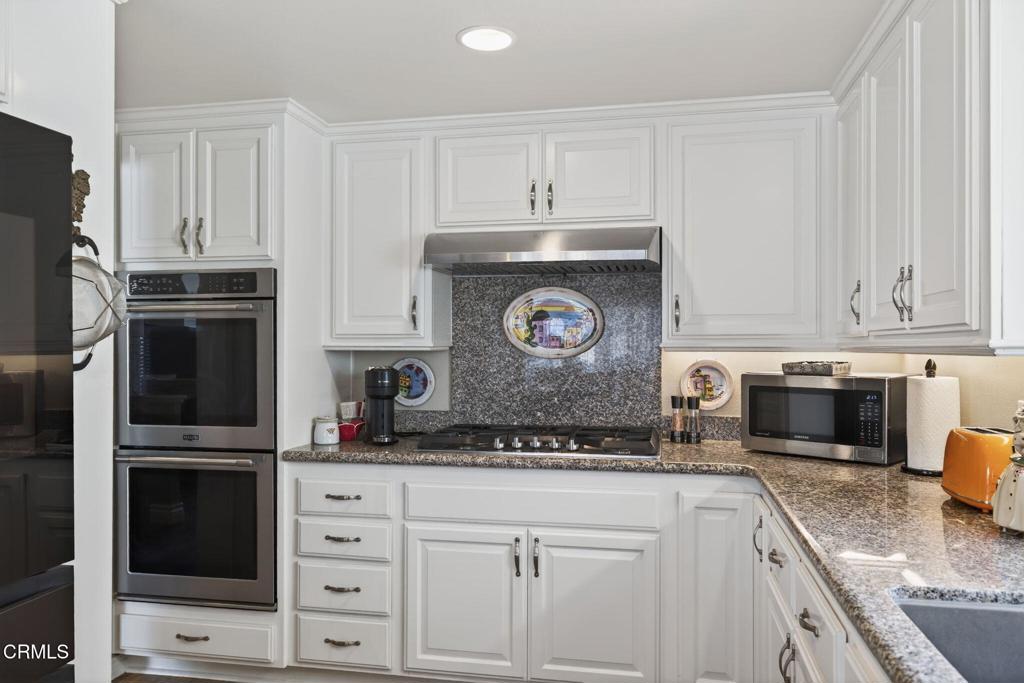 116 Pasadena Avenue Oxnard, CA 93035 - Photo 18 of 52 a kitchen with granite countertop white cabinets and stainless steel appliances