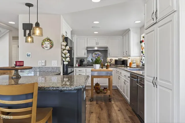 a kitchen with stainless steel appliances granite countertop sink stove top oven and cabinets