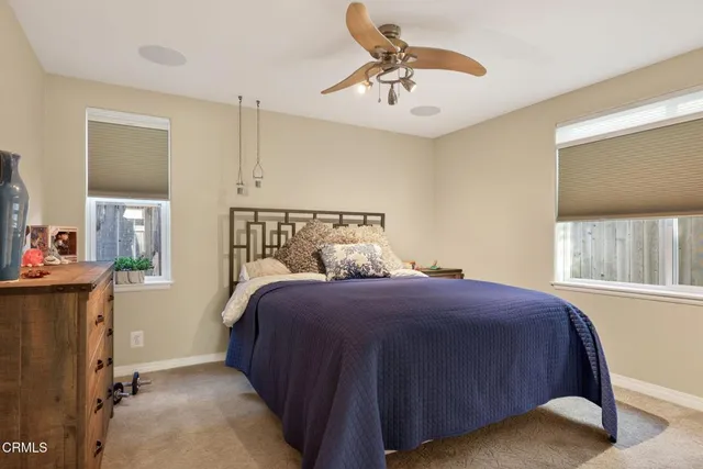a bedroom with a bed a chandelier and dresser