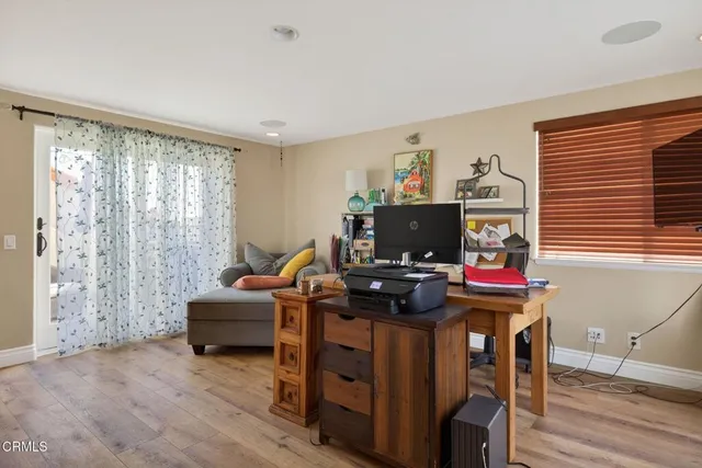 a view of a workspace with furniture and a window