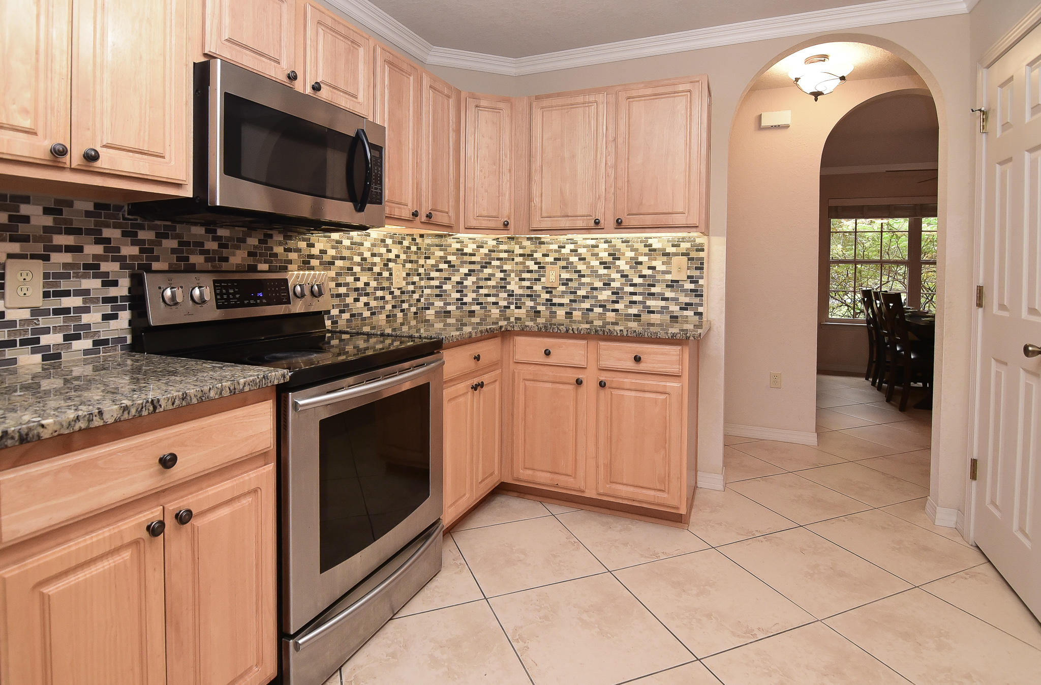4214 Painter Branch Road Crestview, FL 32539 - Photo 16 of 41 a kitchen with granite countertop a stove top oven microwave and cabinets
