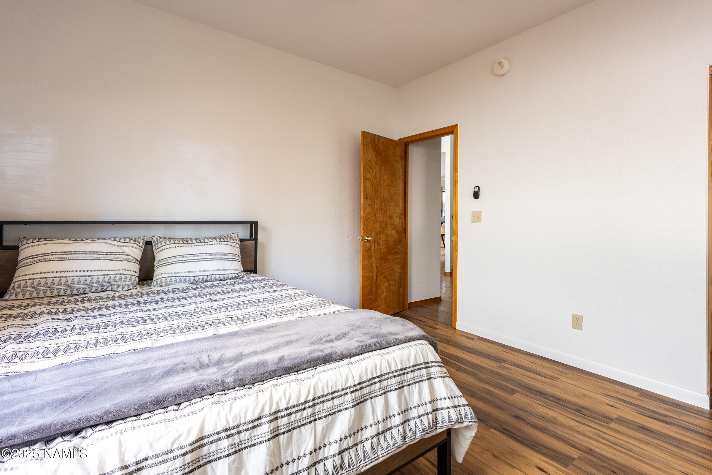 335 Sandia Circle Munds Park, AZ 86017 - Photo 12 of 34 a bedroom with a bed and wooden floor