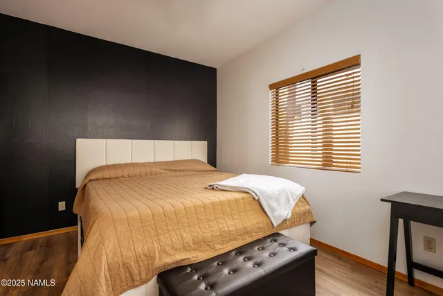 a bedroom with a bed and wooden floor