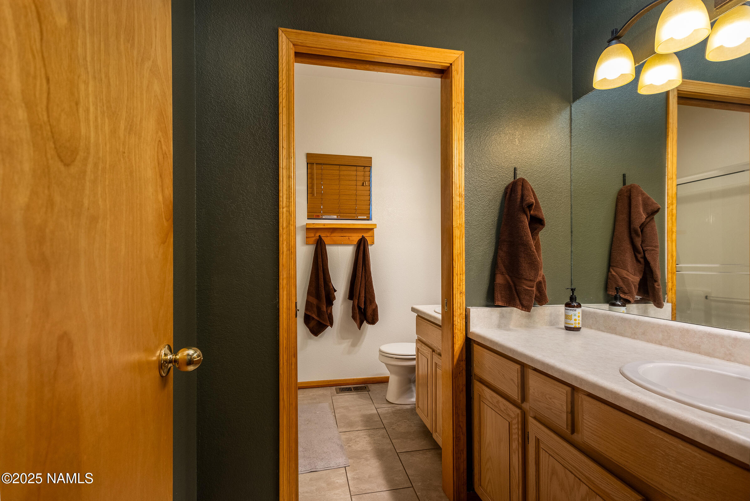 335 Sandia Circle Munds Park, AZ 86017 - Photo 17 of 34 a bathroom with a double vanity sink and a mirror