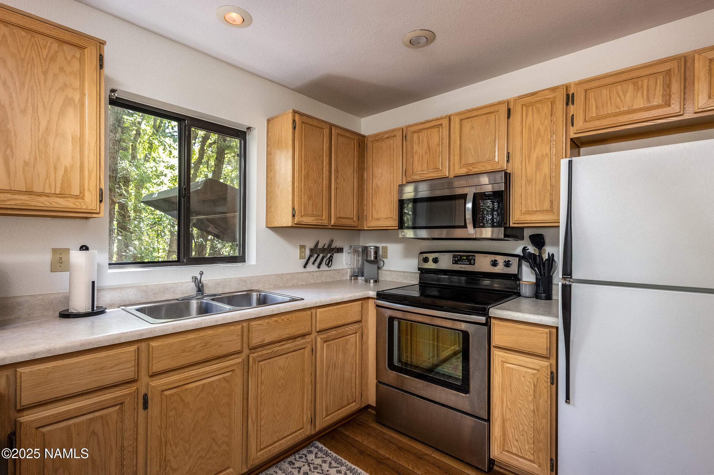335 Sandia Circle Munds Park, AZ 86017 - Photo 8 of 34 a kitchen with appliances a sink and cabinets