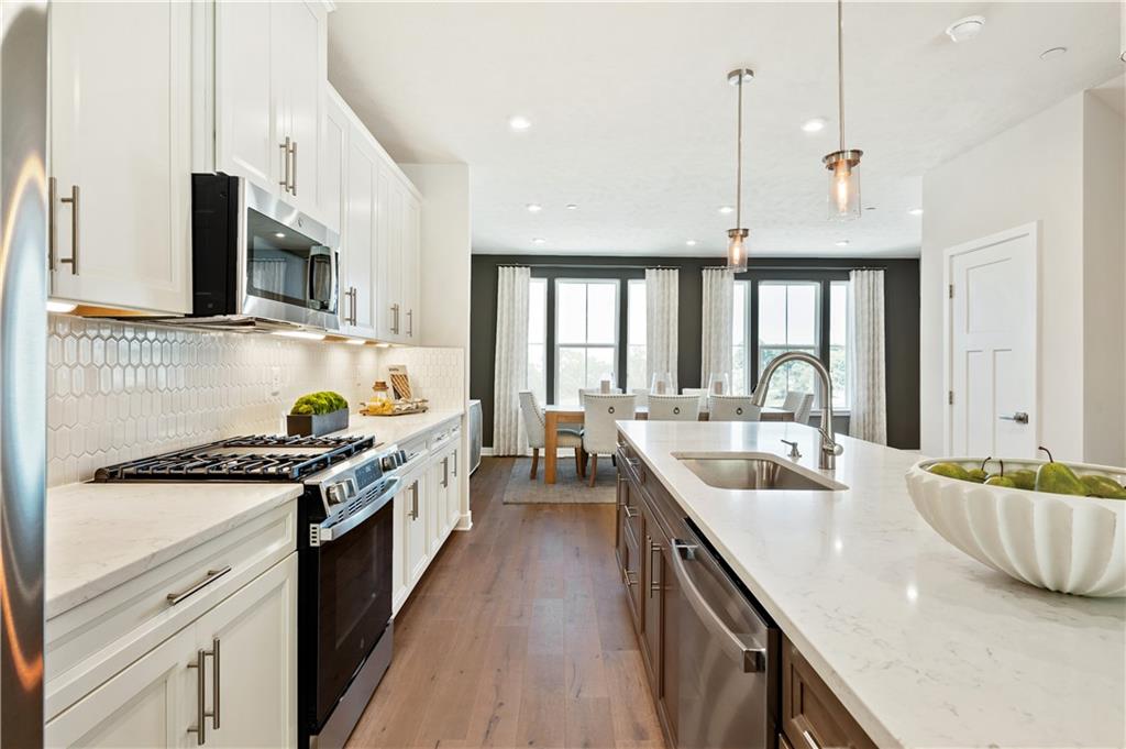 130 Goldenthread Way Coraopolis, PA 15108 - Photo 5 of 27 a kitchen with stainless steel appliances granite countertop a sink a stove and a wooden floors
