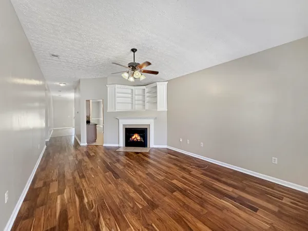 a view of an empty room with a fireplace and chandelier