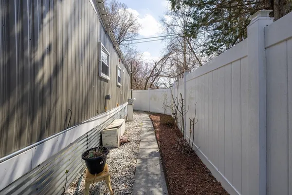 a view of a pathway of a house with wooden fence
