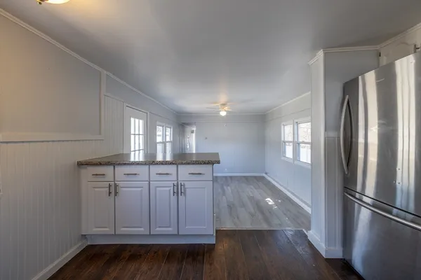 a kitchen with wooden floors and refrigerator