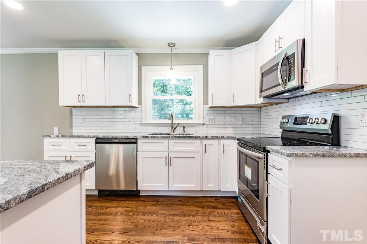 733 St George Road Raleigh, NC 27610 - Photo 14 of 29 a kitchen with stainless steel appliances granite countertop a sink stove and cabinets