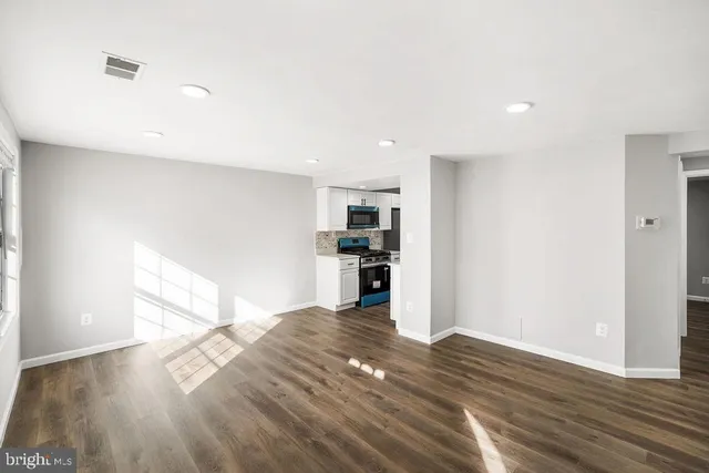 a view of a kitchen with wooden floor and a refrigerator