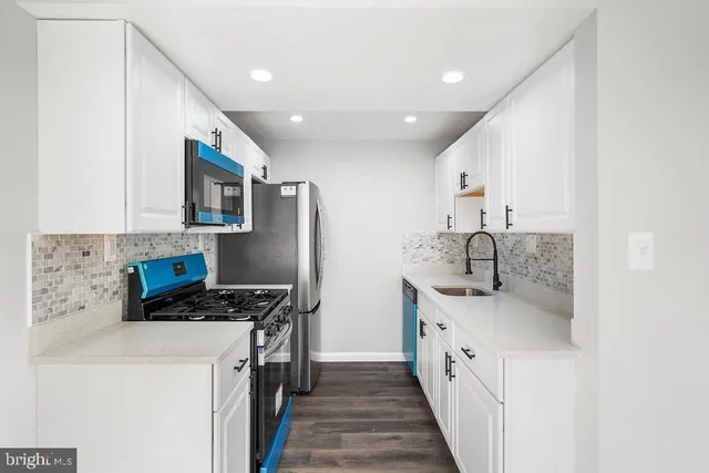 a kitchen with stainless steel appliances a sink stove and cabinets