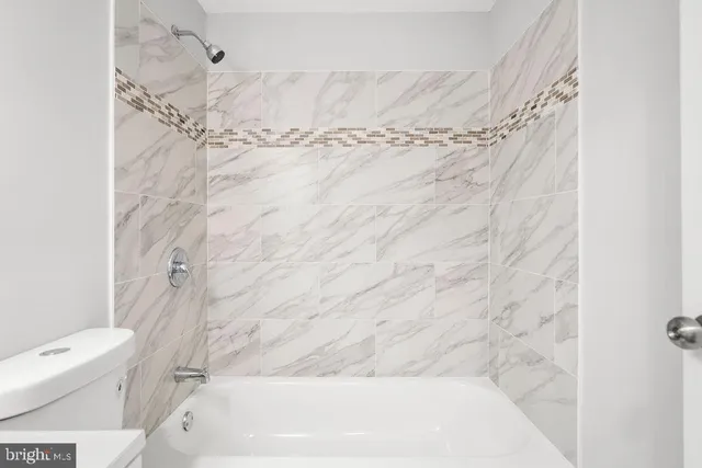a view of an empty room with wooden floor and closet