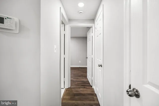 a view of a hallway with wooden floor and closet