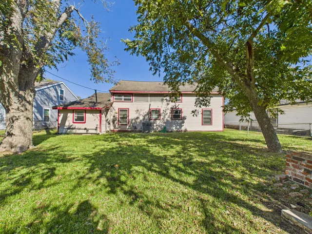 a view of a house with a big yard plants and large trees