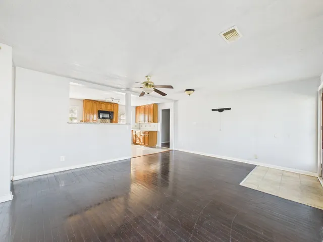 a view of a livingroom with wooden floor and a ceiling fan
