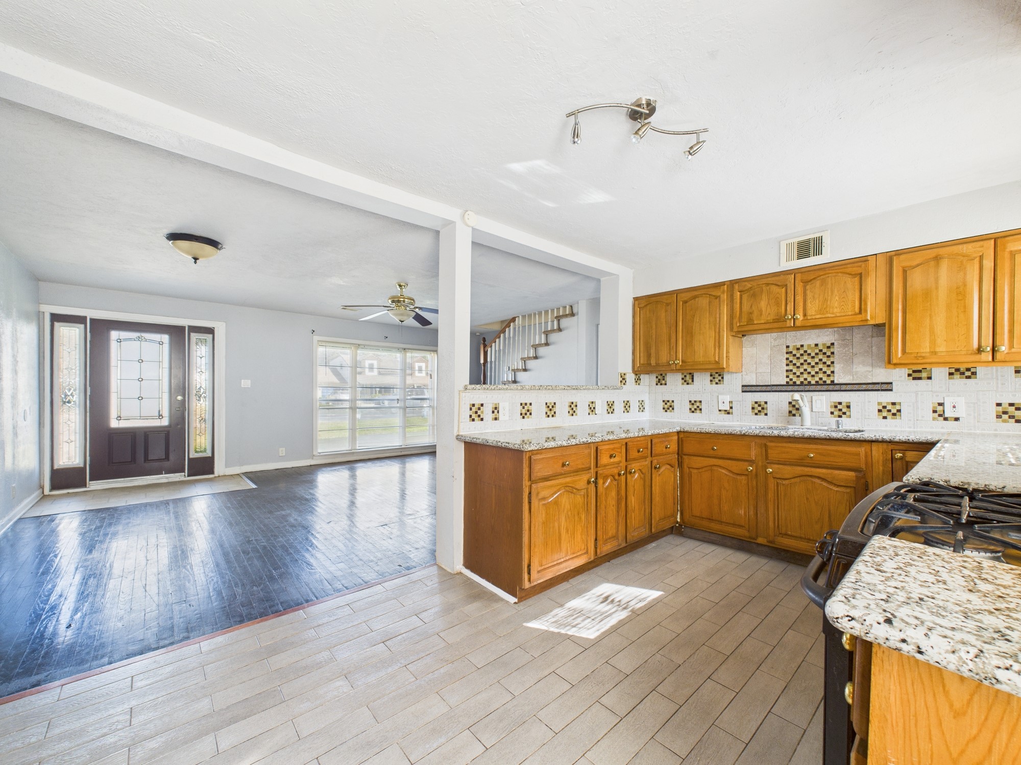 3814 Luca Street Houston, TX 77021 - Photo 7 of 31 a large kitchen with stainless steel appliances granite countertop a stove a sink dishwasher and white cabinets with wooden floor