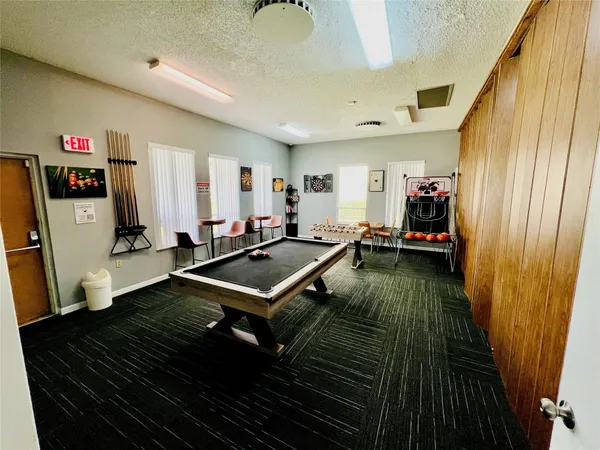a living room with a table chairs and a refrigerator