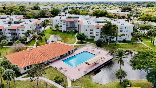 an aerial view of a house with swimming pool a yard and lake view