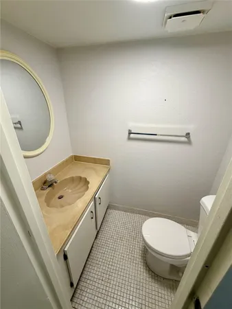 a bathroom with a toilet a sink and mirror