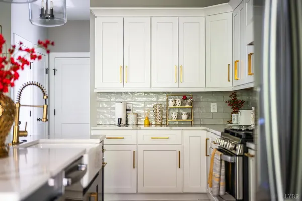 a kitchen with white cabinets and sink