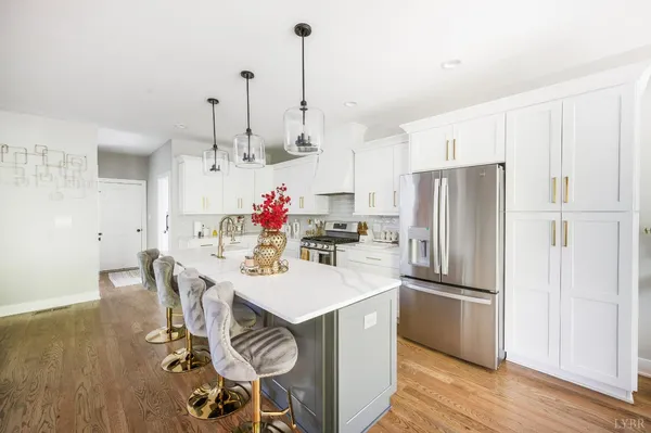 a kitchen with refrigerator and white cabinets