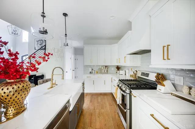 a kitchen that has a lot of white cabinets and a stove