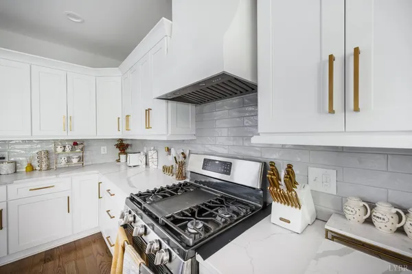 a kitchen with white cabinets and a stove top oven