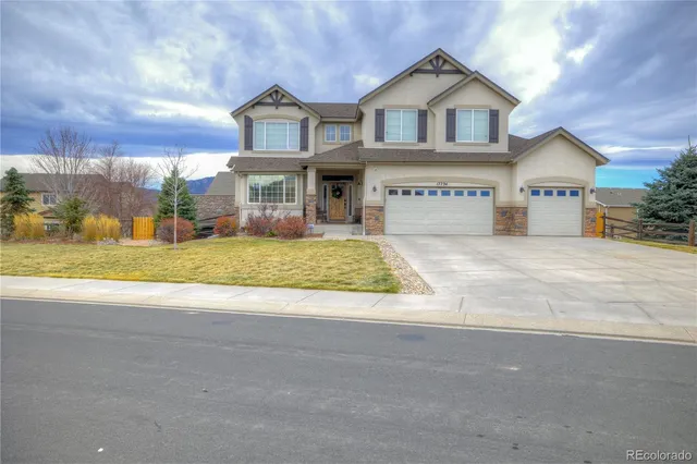 a view of a big house with large windows and a big yard