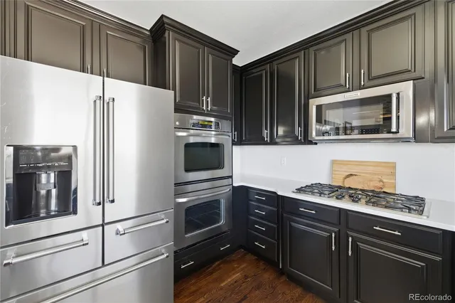 a kitchen with granite countertop a refrigerator stove and microwave